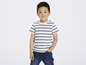 Ein Junge in einem gestreiften T-Shirt und blauen Jeans.