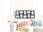 Schwarzer Bilderrahmen mit neun Fotos an der Wand.