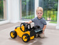 Ein Junge spielt mit einem gelben Spielzeugtraktor.