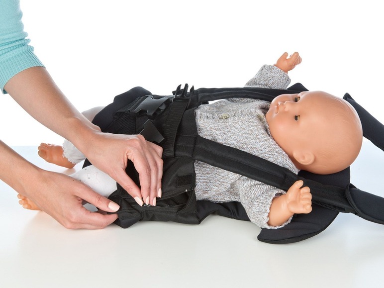 Ein Baby in einem schwarzen Tragetuch.