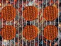 Sechs Hamburger-Patties auf einem Grill.