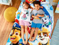 Zwei Kinder liegen auf einem Paw Patrol Bettbezug mit Chase und Skye.
