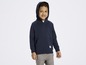 Ein Junge trägt einen dunkelblauen Kapuzenpullover mit Ankerlogo.