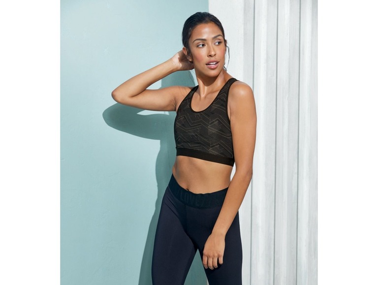 Eine Frau trägt einen schwarzen Sport-BH und Leggings zum Training.