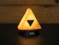 Eine leuchtende Zelda Triforce-Lampe.