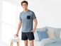 Mann in einem blauen T-Shirt und kurzen Shorts mit Muster.