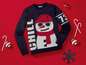 Ein blauer Weihnachtspullover mit einem Schneemann und Zuckerstangen.