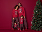 Eine Familie in Weihnachtspyjamas vor einem Weihnachtsbaum.