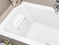 Eine weiße Badewanne mit einem Badekissen.