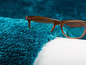 Ein blauer Plüschteppich und eine braune Brille.