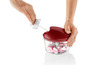 Ein roter Hand-Food-Processor mit roter Zwiebel