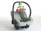 Ein grauer Babysitz mit einem Tiny Love Mobile.