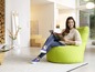 Eine Frau liest in einem grünen Beanbag-Sessel.