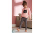 Mädchen trägt einen rosa Pullover mit Katzenmotiv und graue Leggings.