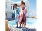 Zwei Kinder mit Disney-Handtüchern am Pool.