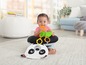 Baby sitzt in einem Sitzsack mit Panda-Motiv und spielt mit Spielzeug.