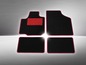 Schwarze Auto Fußmatten mit rotem Rand.