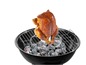 Ein gegrilltes Hähnchen auf einem Holzkohlegrill.