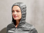 Graue Daunenjacke mit Kapuze für Damen.