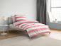 Ein rosafarbenes gestreiftes Bettlaken auf einem Bett.