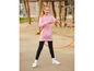 Ein Mädchen mit einem rosa Hoodie und schwarzen Leggings hält einen Hula-Hoop-Reifen.