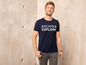 Mann trägt ein dunkelblaues T-Shirt mit dem Aufdruck 'Escape & Explore'.