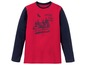 Rot-blaues Langarmshirt mit einem Haus im Waldmotiv.