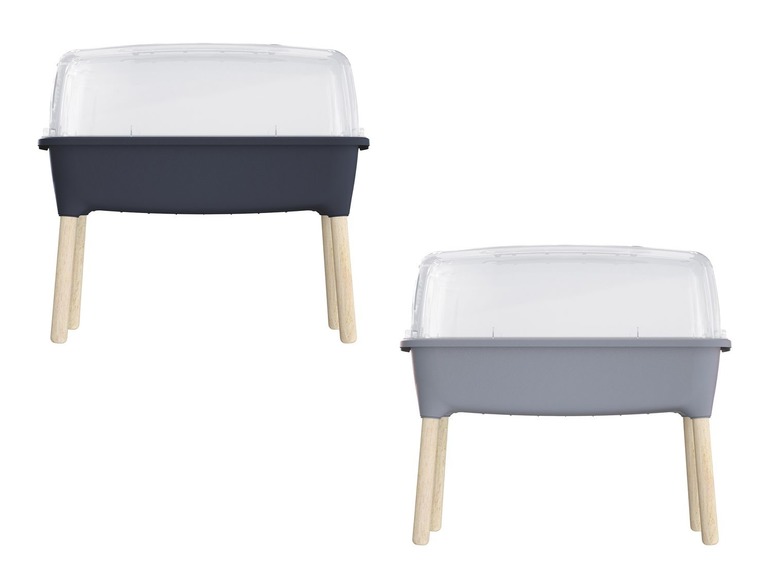 Zwei graue Mini-Gewächshäuser mit Holzbeinen und einer transparenten Haube.