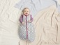 Baby in einem Schlafsack mit Herz- und Sternmuster.