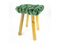 Ein grüner Hocker mit Holzbeinen.