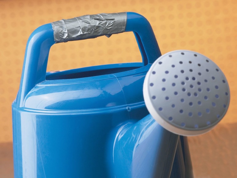 Eine blaue Gießkanne mit grauem Klebeband am Henkel.