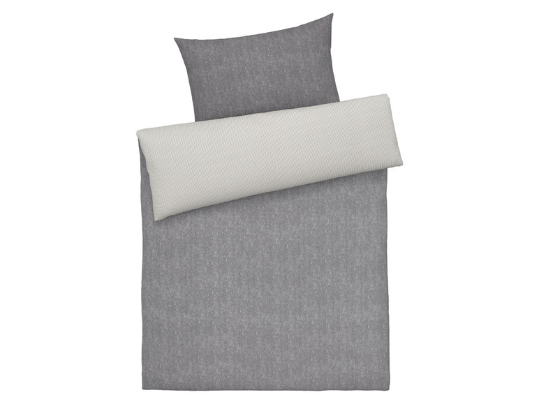 Graue Bettwäsche mit gestreiftem Kissenbezug.