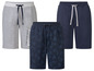Drei kurze Hosen, eine graue, eine dunkelblaue und eine dunkelblaue mit Palmenblatt-Druck.