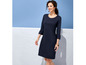 Eine Frau in einem dunkelblauen Kleid mit 3/4-Ärmeln.