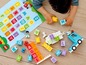 Ein Kind spielt mit LEGO DUPLO Buchstaben und einem blauen LKW.