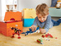 Ein Junge spielt mit LEGO Creator 3-in-1-Sets, darunter ein Hai, ein Krebs und ein Roboter.