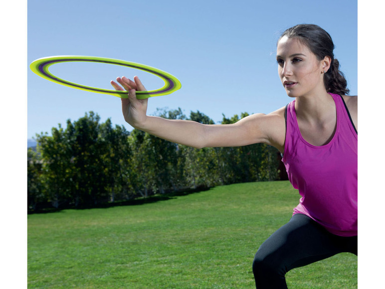 Eine Frau wirft eine Frisbee in einem Park.