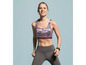 Eine Frau trägt einen Sport-BH mit Muster und Leggings.