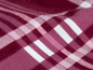Nahaufnahme von rotem Stoff mit weißem Karomuster.