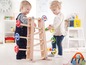 Zwei Kinder spielen mit einer Holzbahn und einem Spielzeugauto.