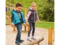 Zwei Kinder tragen Jacken und Sneakers auf einem Spielplatz.