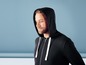 Mann trägt einen schwarzen Hoodie mit weißen Kordeln.