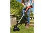 Ein Mann verwendet eine Black & Decker GrasTrimmer in seinem Garten.