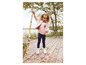 Ein kleines Mädchen trägt einen rosa Pullover, blaue Leggings und weiße Schuhe.