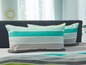 Zwei gestreifte Kissen mit türkisfarbenen und grauen Streifen auf einem Bett.