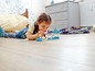 Ein Kind spielt mit LEGO DUPLO Figuren von Frozen und einem kleinen Schloss.