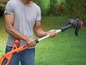 Ein Mann benutzt eine Black+Decker Grasschneider in seinem Garten.