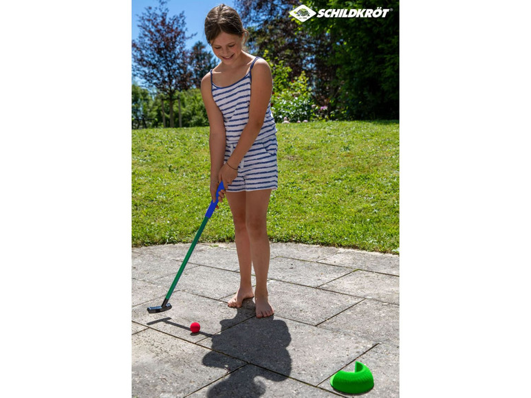 Ein Mädchen spielt Minigolf mit einem Putter und einem Ball von Schildkröt.