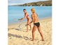 Zwei Frauen spielen Beachtennis am Sandstrand.