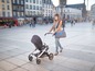 Eine Frau schiebt einen BabyZen Yoyo Kinderwagen durch die Stadt.